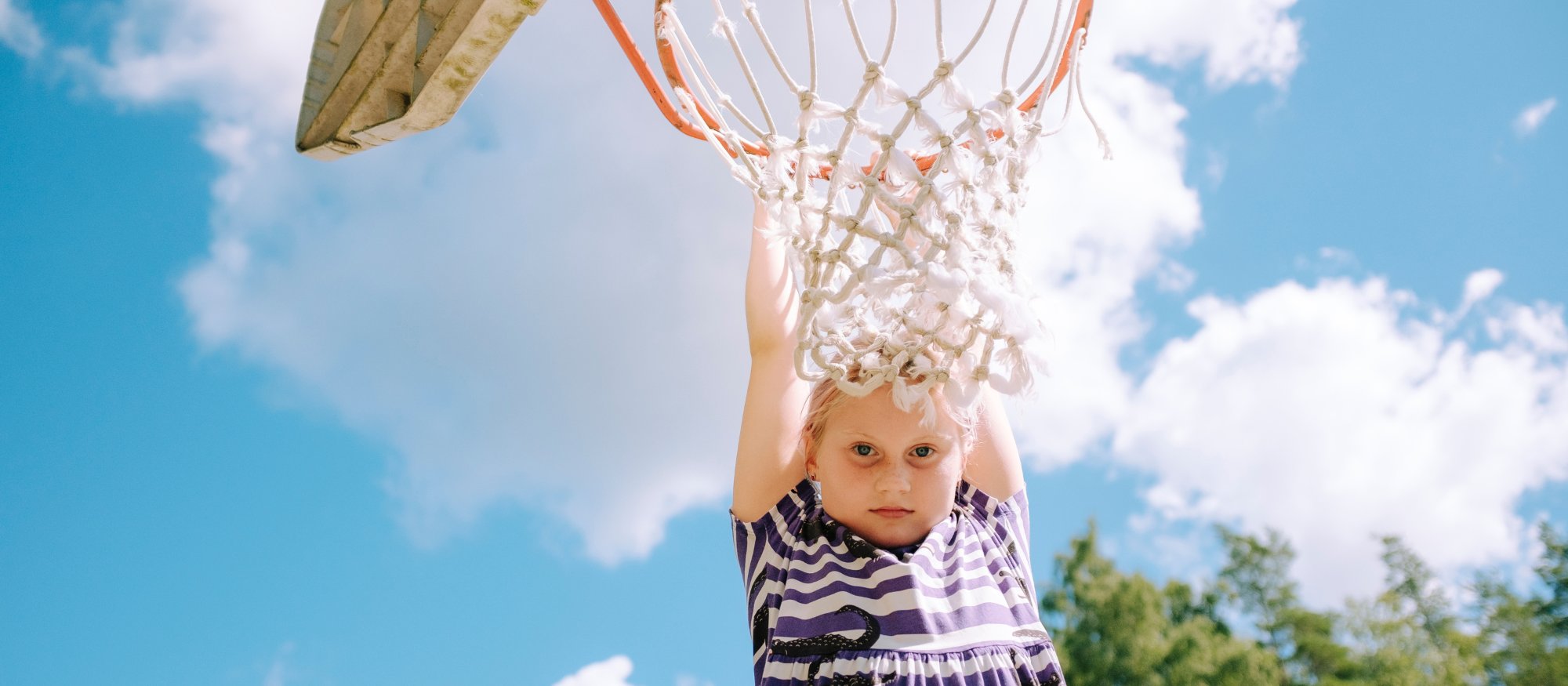 Flicka hänger i basketkorg