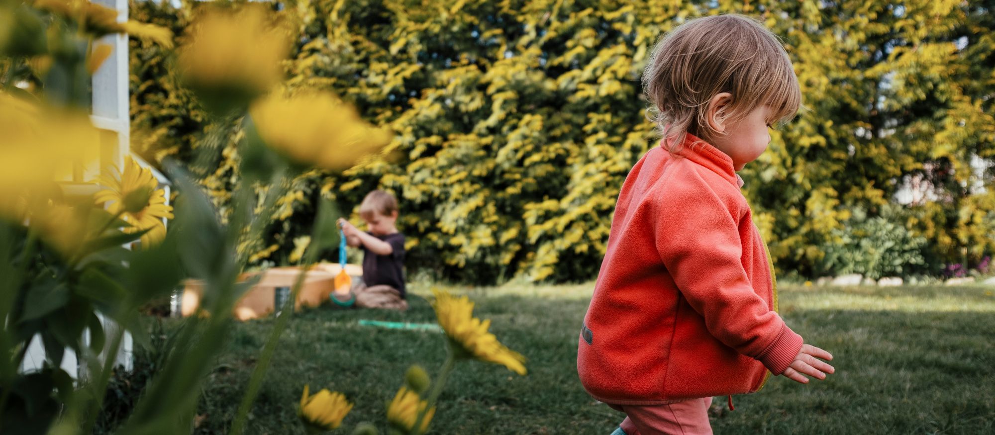 Barn springer i en trädgård på våren